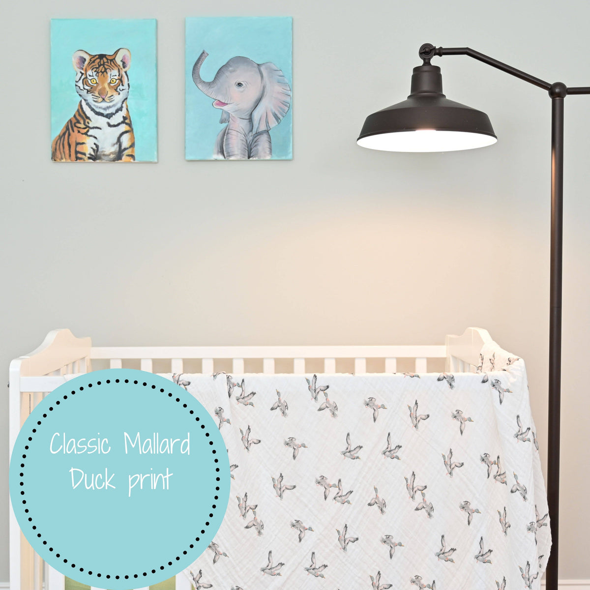 Nursery with crib, lamp, and wall art of a tiger and an elephant.