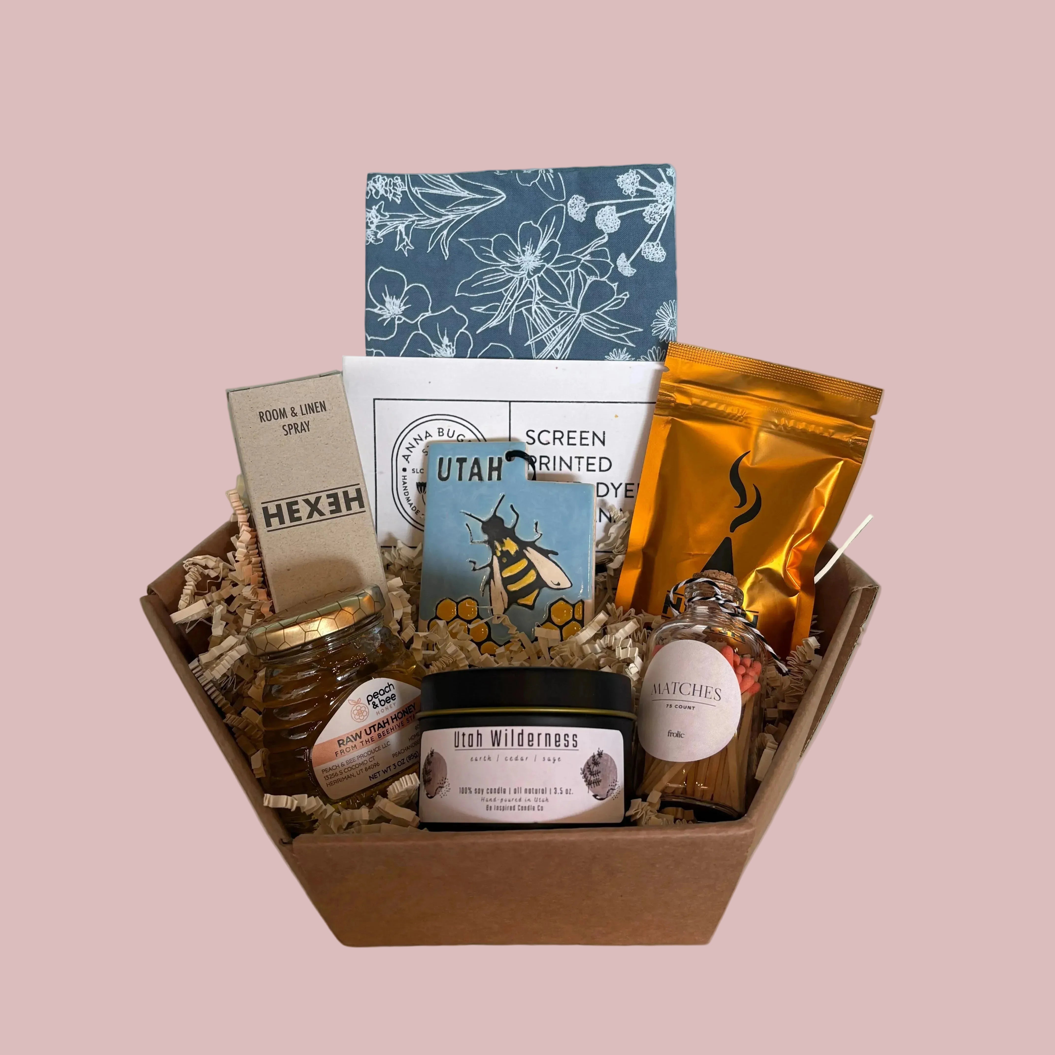 gift Box of assorted items including a book and jars on a light blue surface