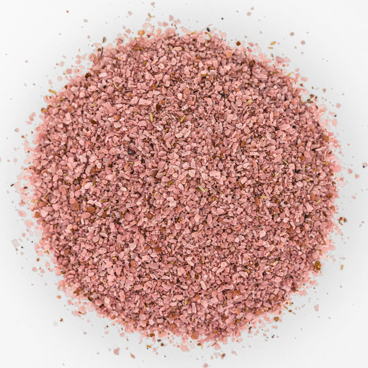Mound of dark pink salt with flecks of herbs and spices.