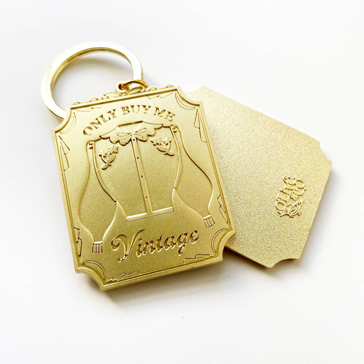 Carry your commitment to sustainable style with this brushed brass keychain. Featuring the bold "ONLY BUY ME VINTAGE" message on one side and the Olive & Co logo on the reverse, it's a daily reminder to shop consciously. Perfect for vintage enthusiasts who want to celebrate their values while keeping keys organized in style.