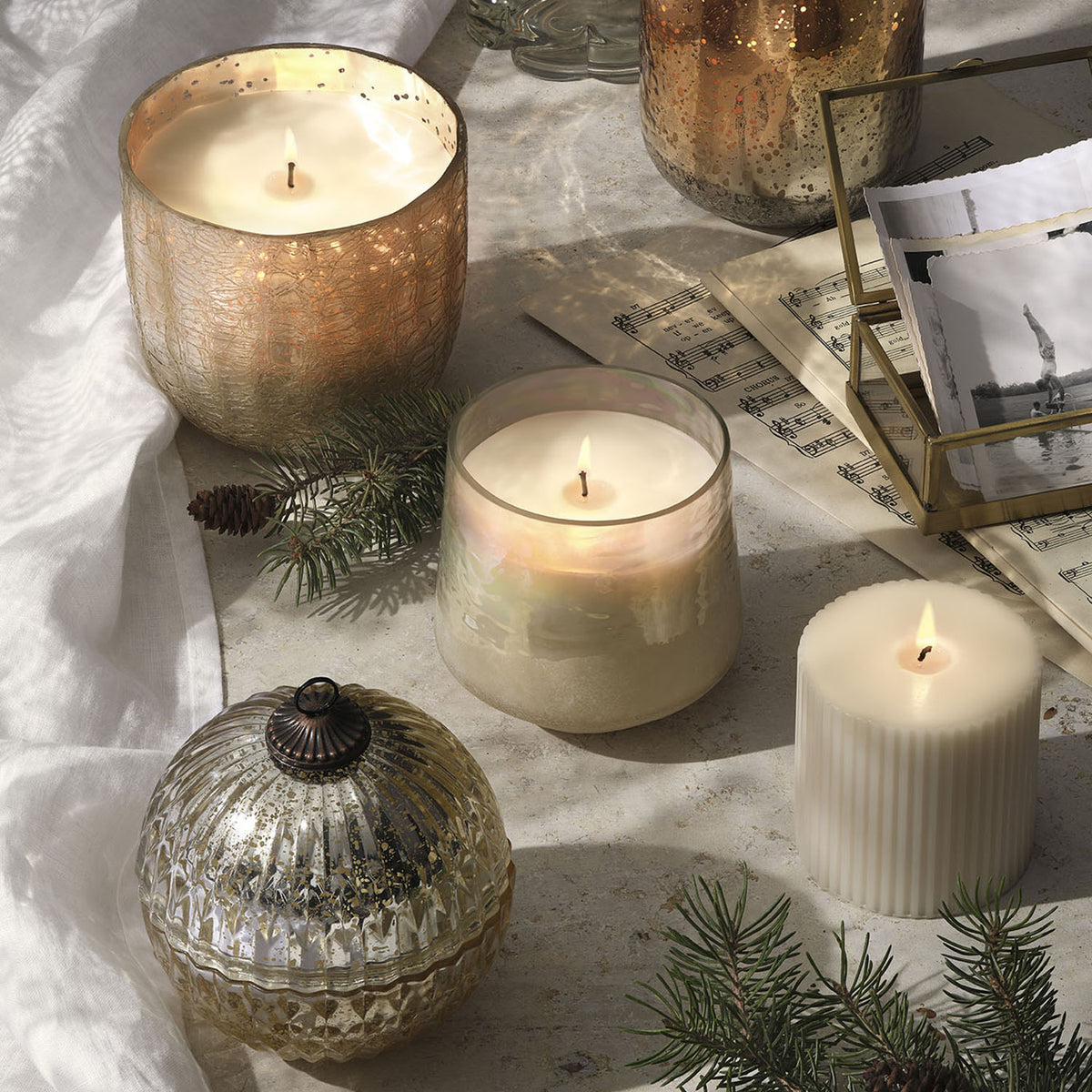 Decorative candles and ornaments on a textured surface with a soft focus