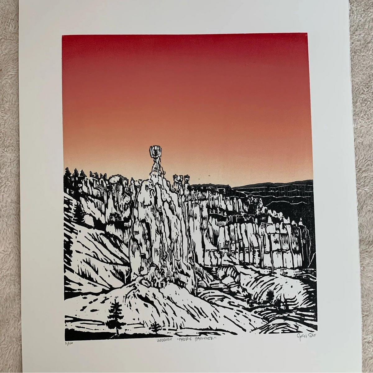 hand block printed woodcut of Thor's Hammer in Bryce Canyon in black and white with a red/orange/yellow gradient sky behind