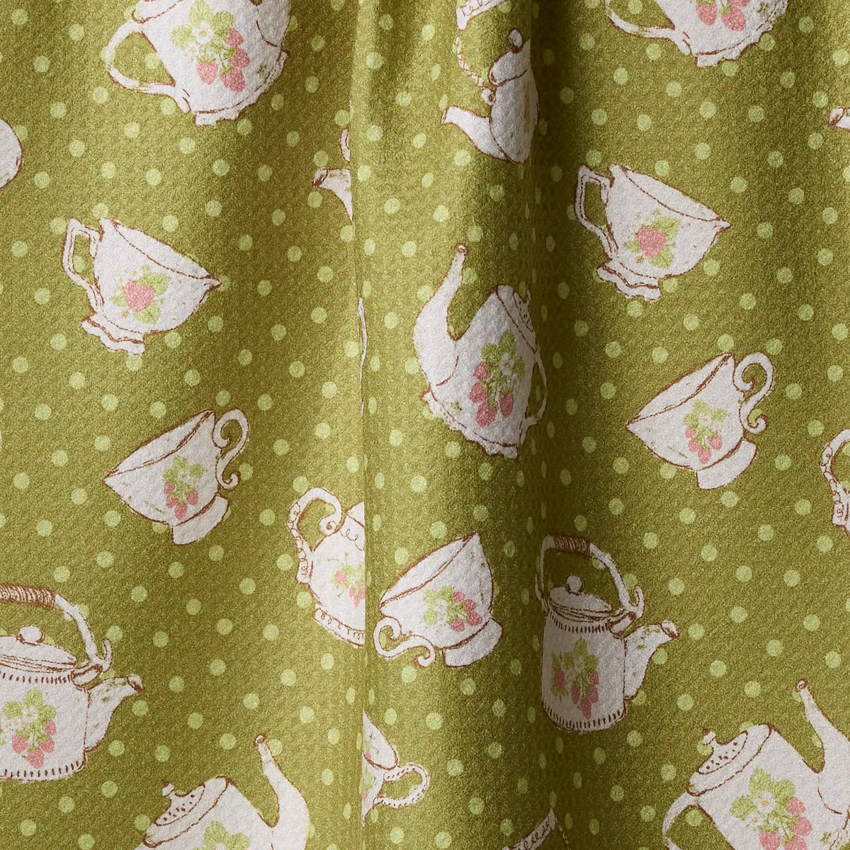 tea towel with teapot and cup pattern on a green background