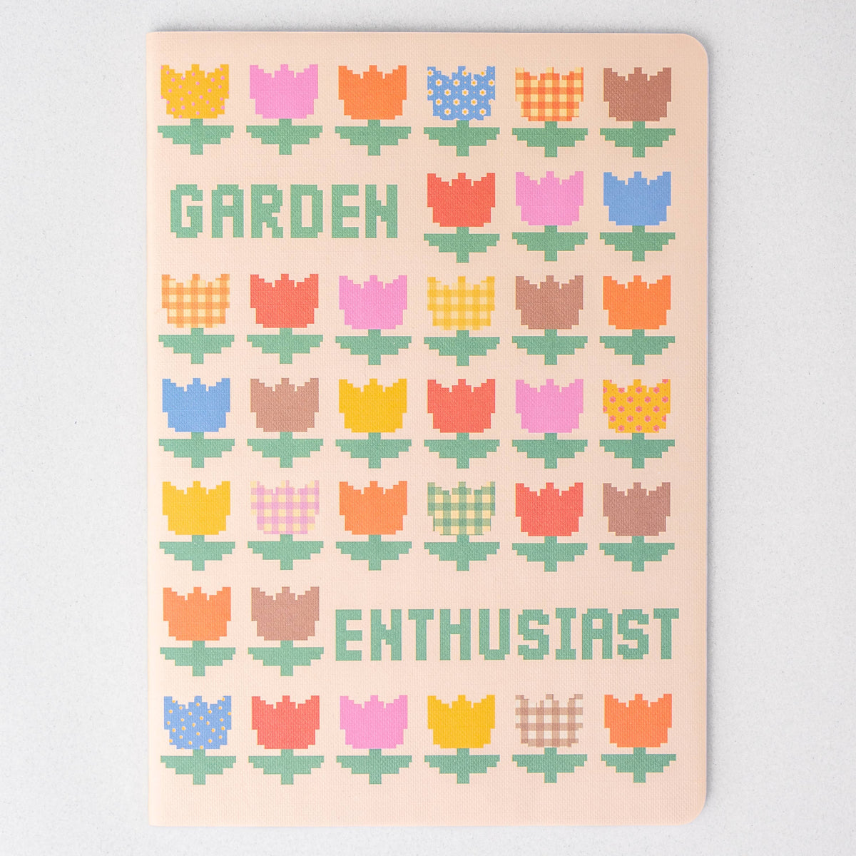 Notebook with colorful tulip pattern and 'Garden Enthusiast' text on a light pink background