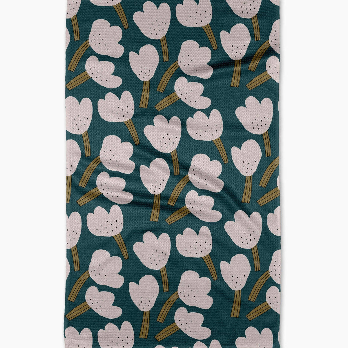 white tea towel floral pattern on a teal background hanging against a plain wall.