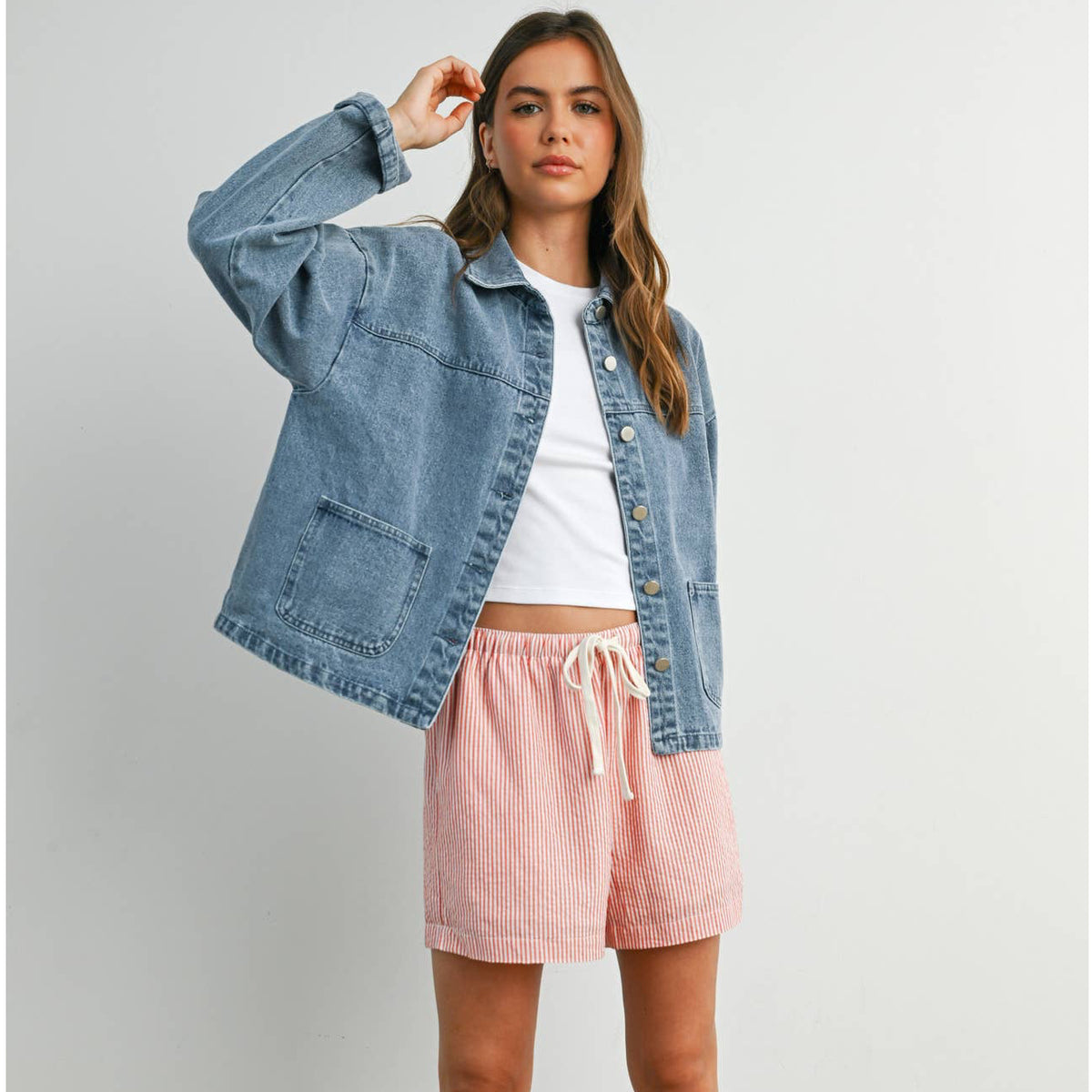 Medium wash denim jacket with silver buttons, box pockets, and collar.