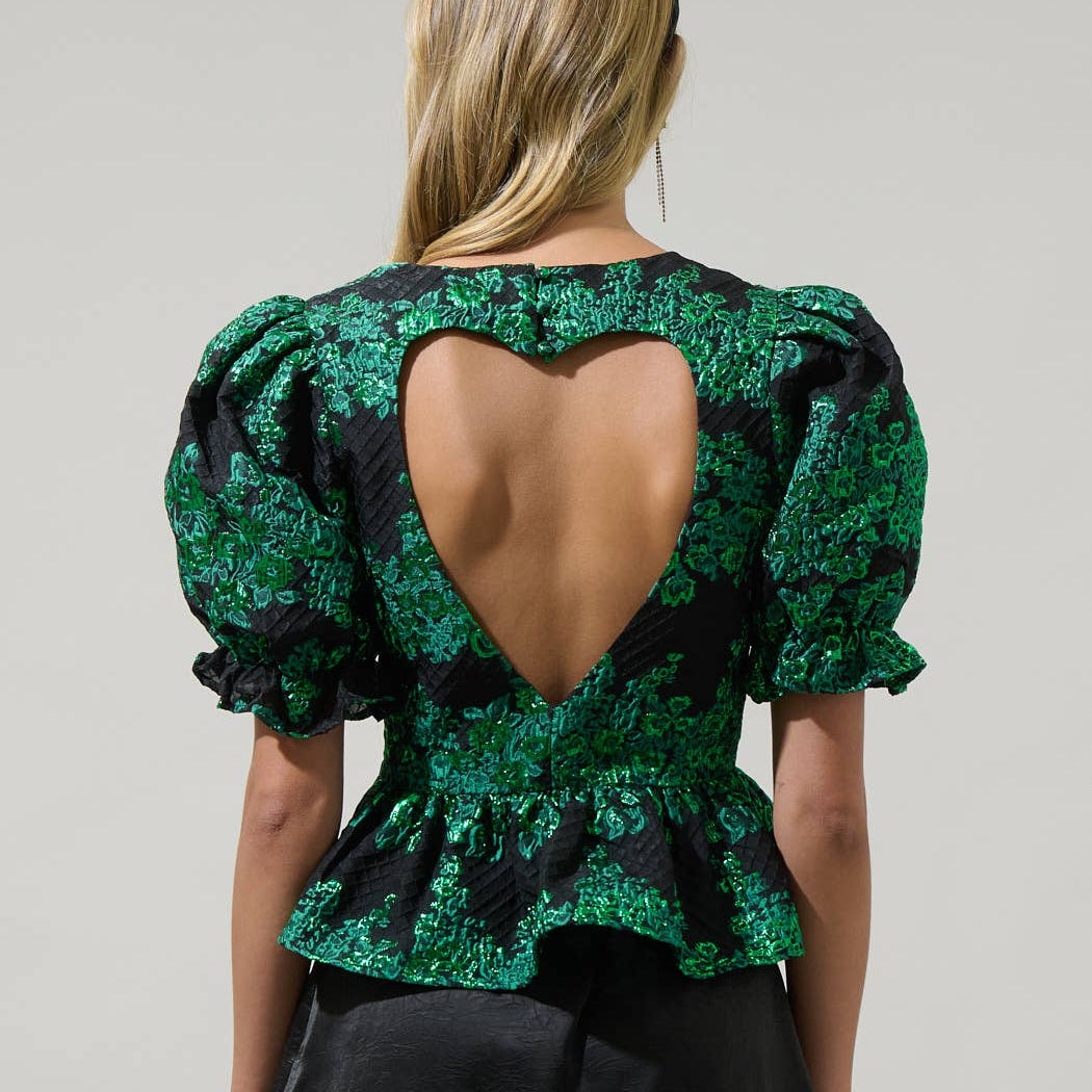 Whatever your plans may be, keep it cute when you wear the Elyna Jacquard Alena Cut Out Blouse. Short puff sleeves with elastic cuffs frame a round neckline that leads to a cute out heart shape in the back. It has a peplum touch at the end. Wear it with a skirt or pants to create a lovely look.
Details:
Puff sleeve
Heart cut out Peplum
Zipper
Color: Green/Black
Model is 5'9"" and wearing size XS
Measurements taken from size S - Chest: 17 1/2"" - Length: 22 1/4""