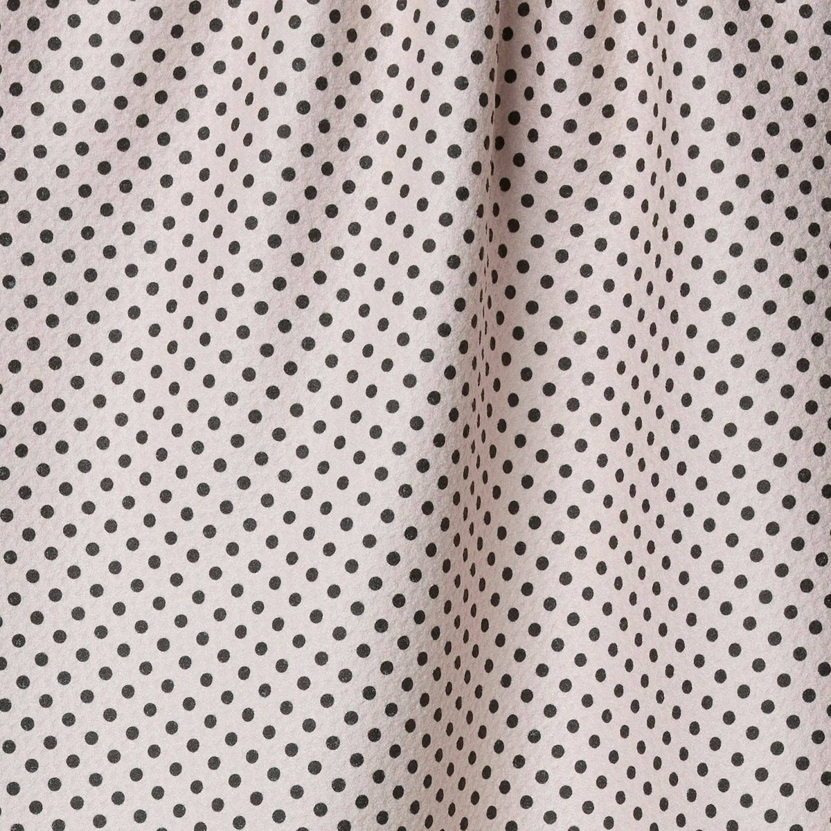 Close-up of ftea towel with small black polka dots on a beige background