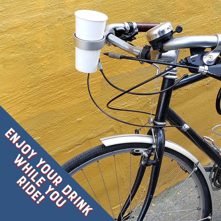 Bicycle with a cup holder attached against a yellow wall