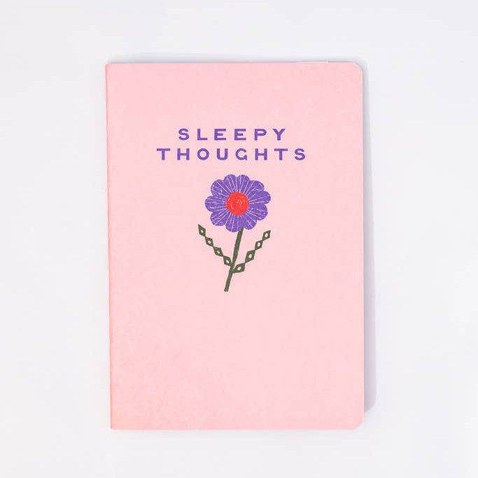 Notebook with 'Sleepy Thoughts' text and a flower illustration on a pink cover.