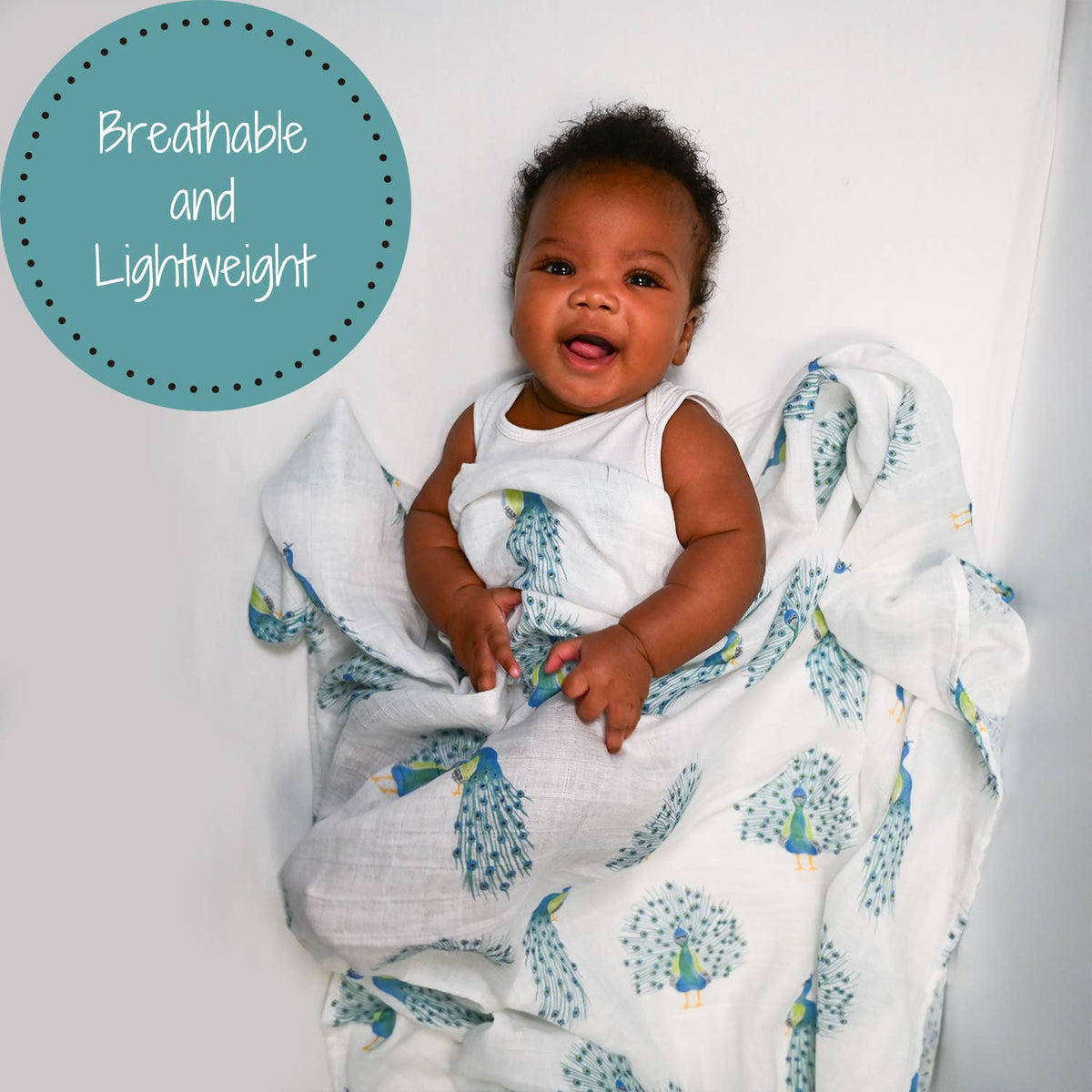 A baby wrapped in a white muslin blanket with a blue and green peacock pattern, lying on a white surface. A teal circular graphic in the top left reads 'Breathable and Lightweight'.