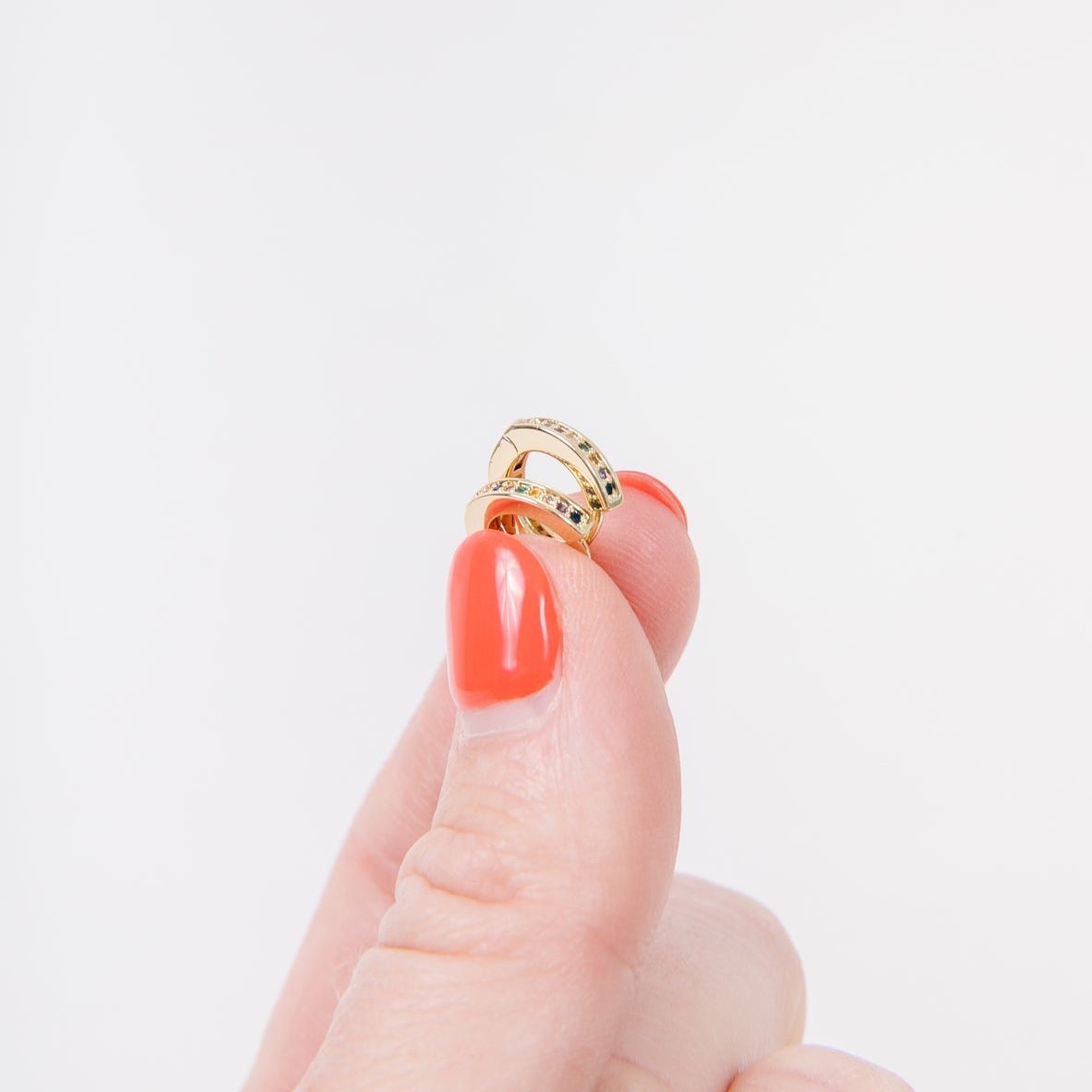 14k Gold Filled 12 mm huggie clasp Safe for sensitive skin Unique clasp has no post when earrings are closed, allowing for comfortable wear and sleep without having to remove earrings Multicolored bejeweld stones are 2 mm Perfect for mulitple piercings Freaking cute and freaking tiny