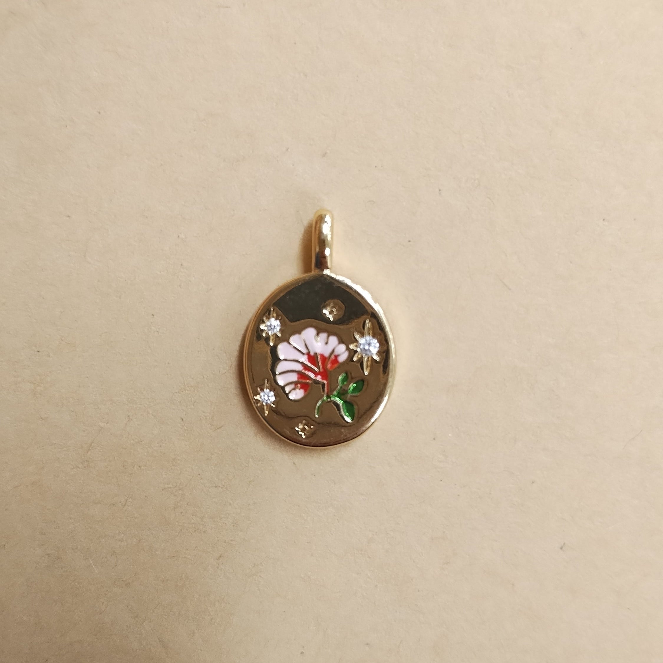 Gold oval pendant charm with a pink enamel flower and inset diamond sparkles.
