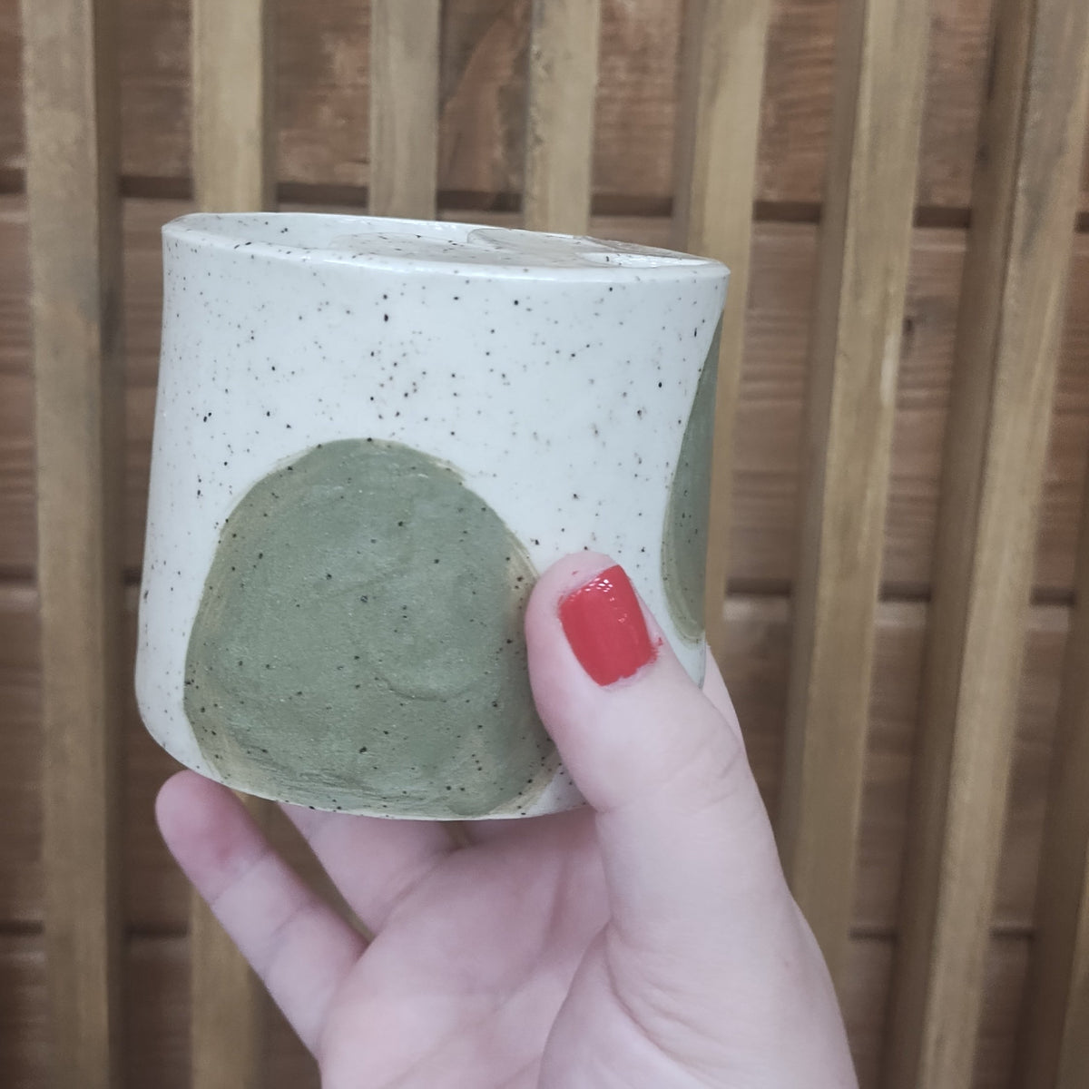 Small ceramic tumbler with large olive green dots.
