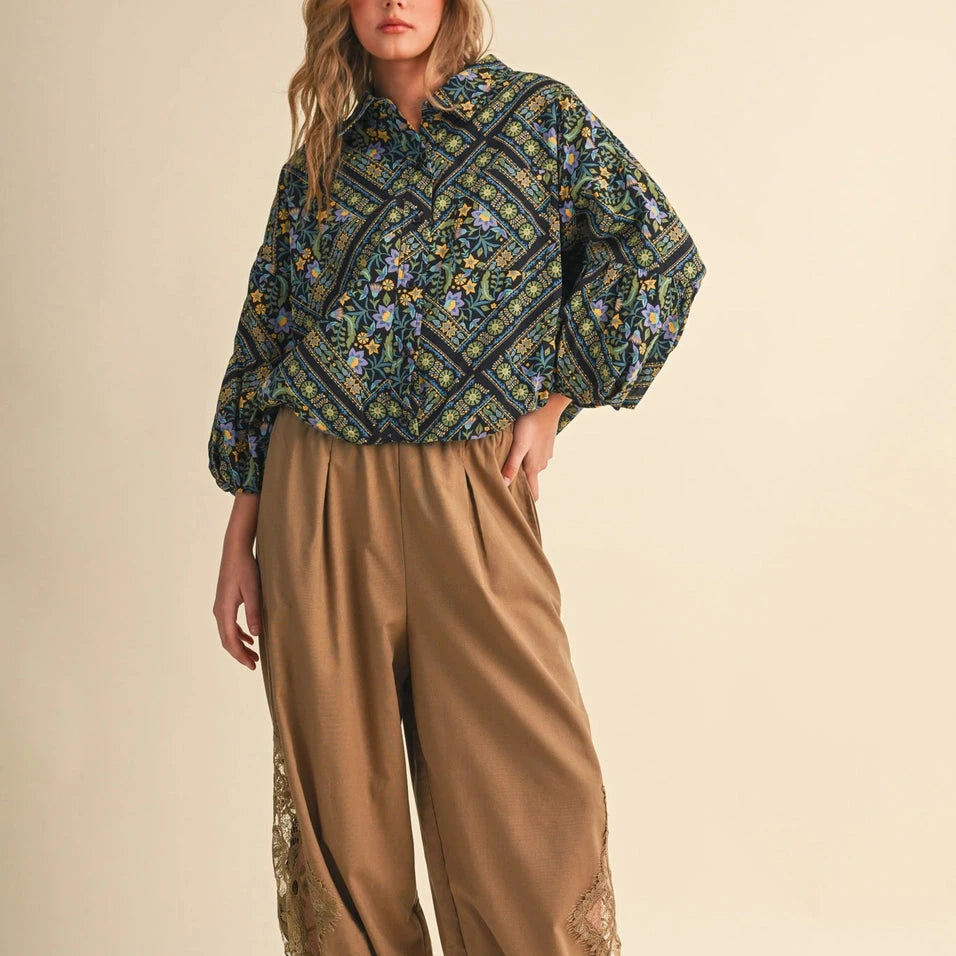 Embrace effortless elegance with this Dark Floral Bubble Sleeve Top from &merci. Featuring an exclusive floral border print, this charming button-down blouse combines timeless style with modern comfort. The collared neckline, drop shoulders, and playful bubble cuffs create a flattering silhouette that feels both polished and relaxed. Crafted from 100% cotton, it's perfect for layering or wearing solo. A versatile piece that transitions beautifully from casual days to dressed-up occasions.