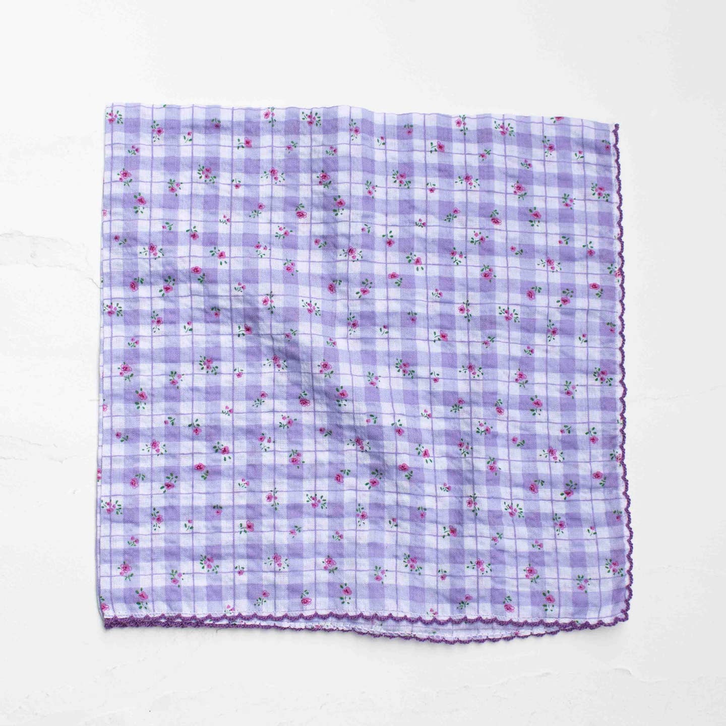 A delicate blend of vintage charm and everyday versatility, this square scarf features a soft plaid background accented with tiny floral prints. The lightweight cotton-rayon blend offers a breathable, silky feel with a gentle drape, making it perfect for year-round styling. Finished with subtle scalloped edges for an added feminine touch.
Wear it as a neck scarf, hair accessory, bag accent, or even as a petite wrap—an easy piece to elevate any look.