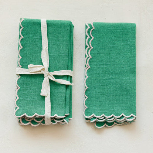 Bring charm and effortless elegance to your dining table with this Scalloped Cotton Napkin Set in vibrant green. Thoughtfully designed with playful scalloped borders and contrasting stitched edges, these soft cotton napkins add a cozy, welcoming feel to any gathering. Beautifully bundled as a set of four with delicate cotton tape, they make a lovely addition to your home or a heartwarming gift for someone special.