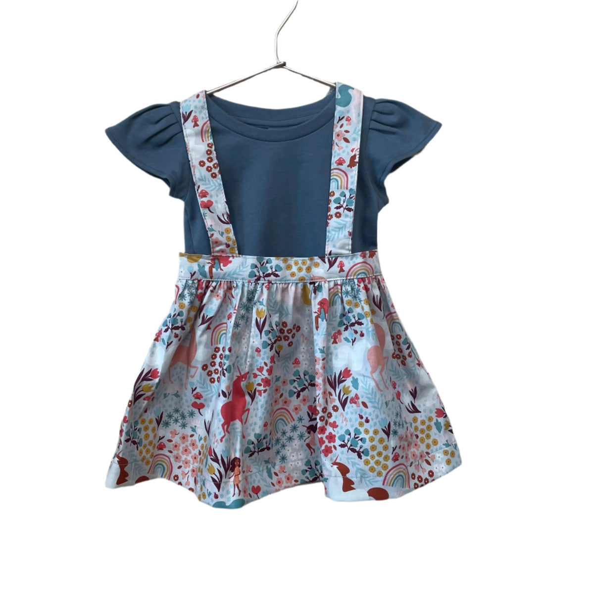 The Andi mini trouser skirt has adjustable suspenders with a button on the back. Two button holes are sewn on each suspender strap so your child can grow with their skirt making it easy to wear high on her waist when they are younger & on their natural waist when older. Fabric designed by Ashley Collett for Riley Blake.