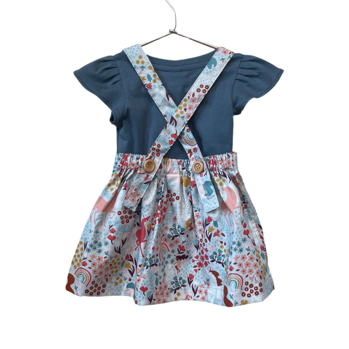 The Andi mini trouser skirt has adjustable suspenders with a button on the back. Two button holes are sewn on each suspender strap so your child can grow with their skirt making it easy to wear high on her waist when they are younger & on their natural waist when older. Fabric designed by Ashley Collett for Riley Blake.