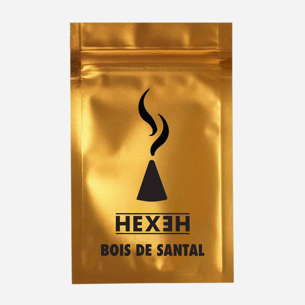A shiny gold metallic pouch features a central black graphic of a stylized incense cone with rising smoke curls above it, accompanied by the brand name "HEXEH" in bold uppercase letters and the product name "BOIS DE SANTAL" below. The pouch is photographed straight-on against a plain light background, highlighting its reflective surface and clean, minimalist design.