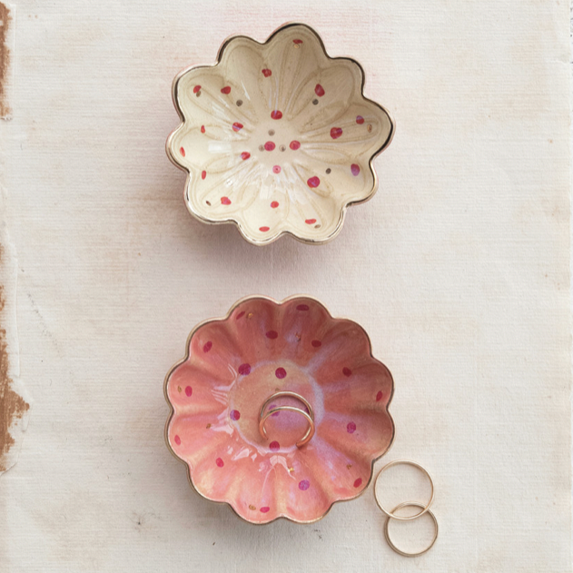 Two ceramic flower-shaped bowls on a textured surface