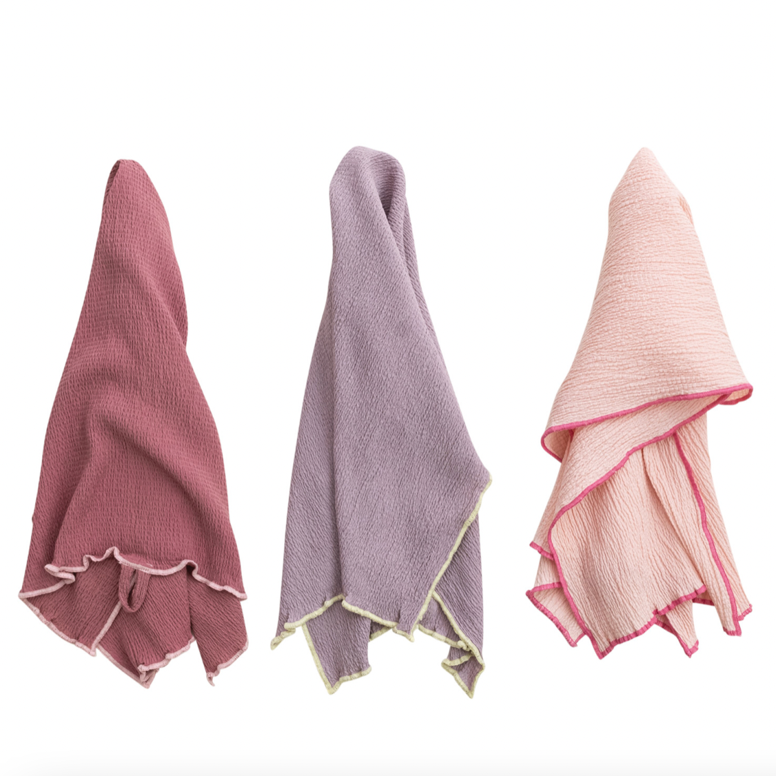 Three textured towels in pink, gray, and light pink on a white background