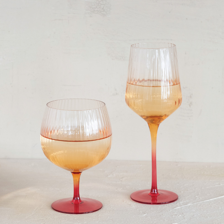 Two wine glasses with a gradient color design on a light background