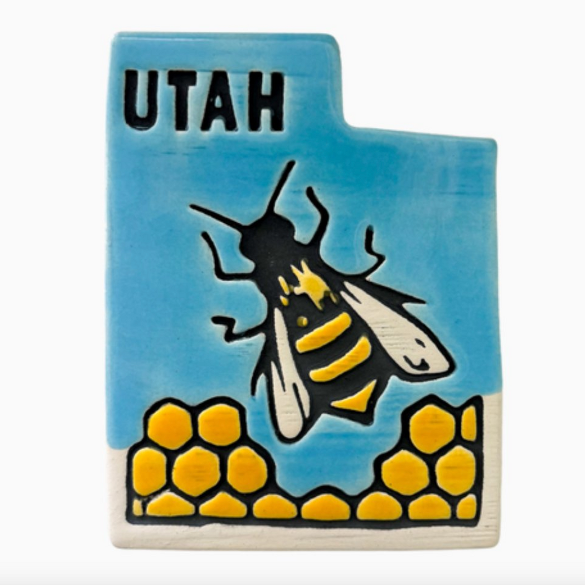 Ceramic ornament in the shape of Utah featuring some honeycomb and a honeybee.