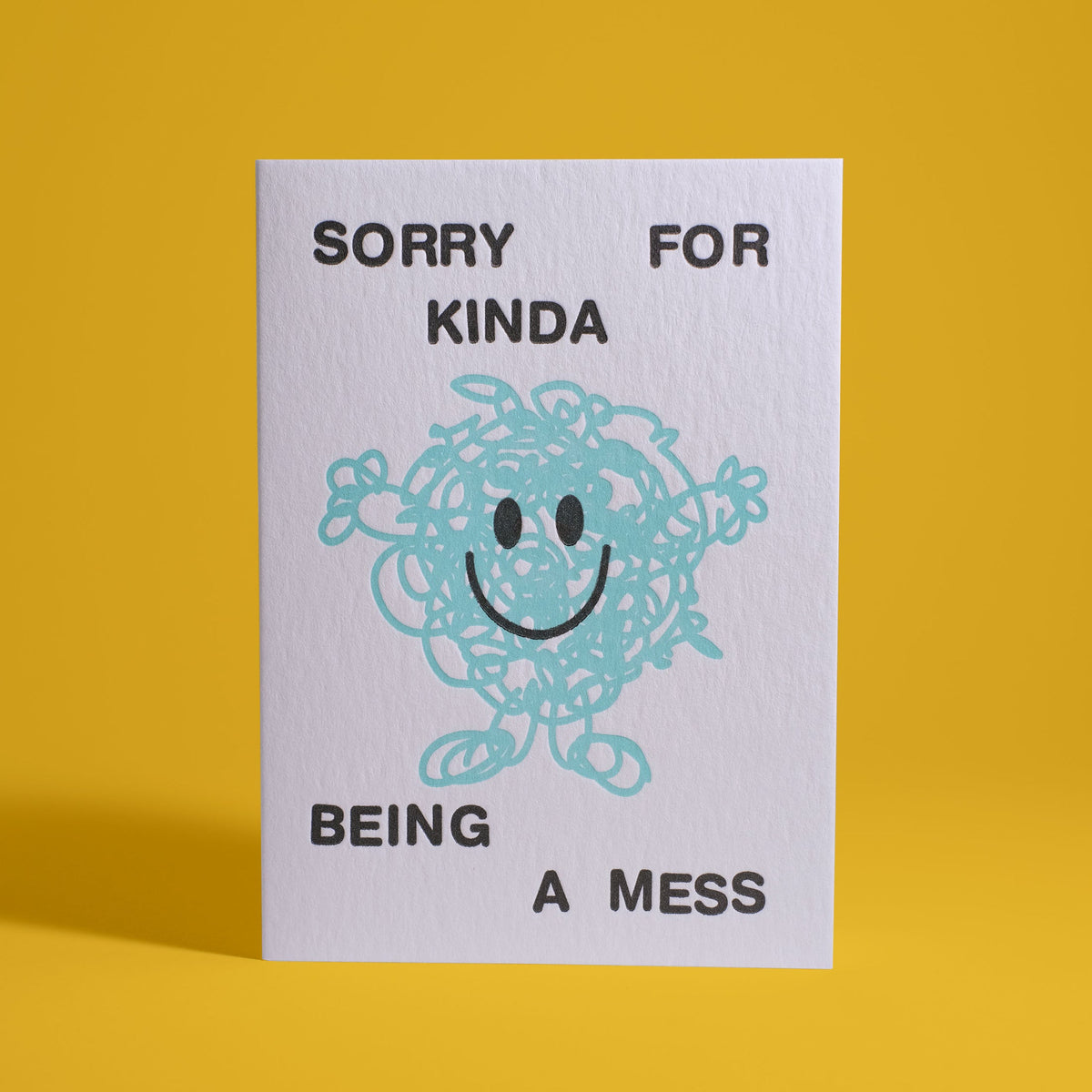 White card with black lettering. Says "Sorry for Kinda Being a Mess". Cute scribble figure smiles with arms stretched outward.