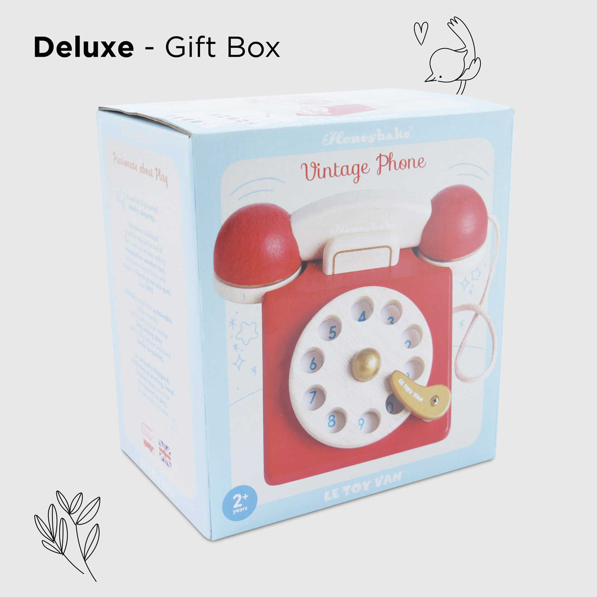 Gift box with a vintage phone toy on a light gray background