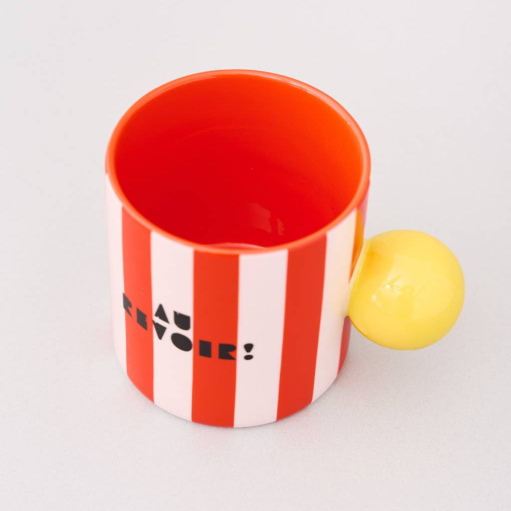 Red and white striped mug with a yellow handle on a light gray background