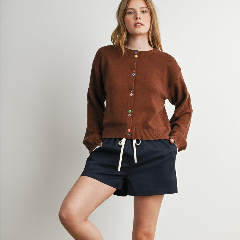 Brown knit long-sleeved cardigan with colorful gingham functioning buttons along front.