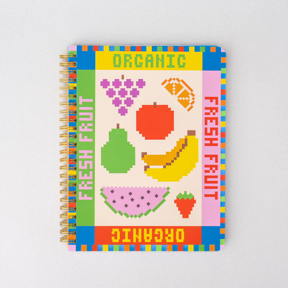 Notebook with colorful fruit illustrations and 'Organic' text on a white background