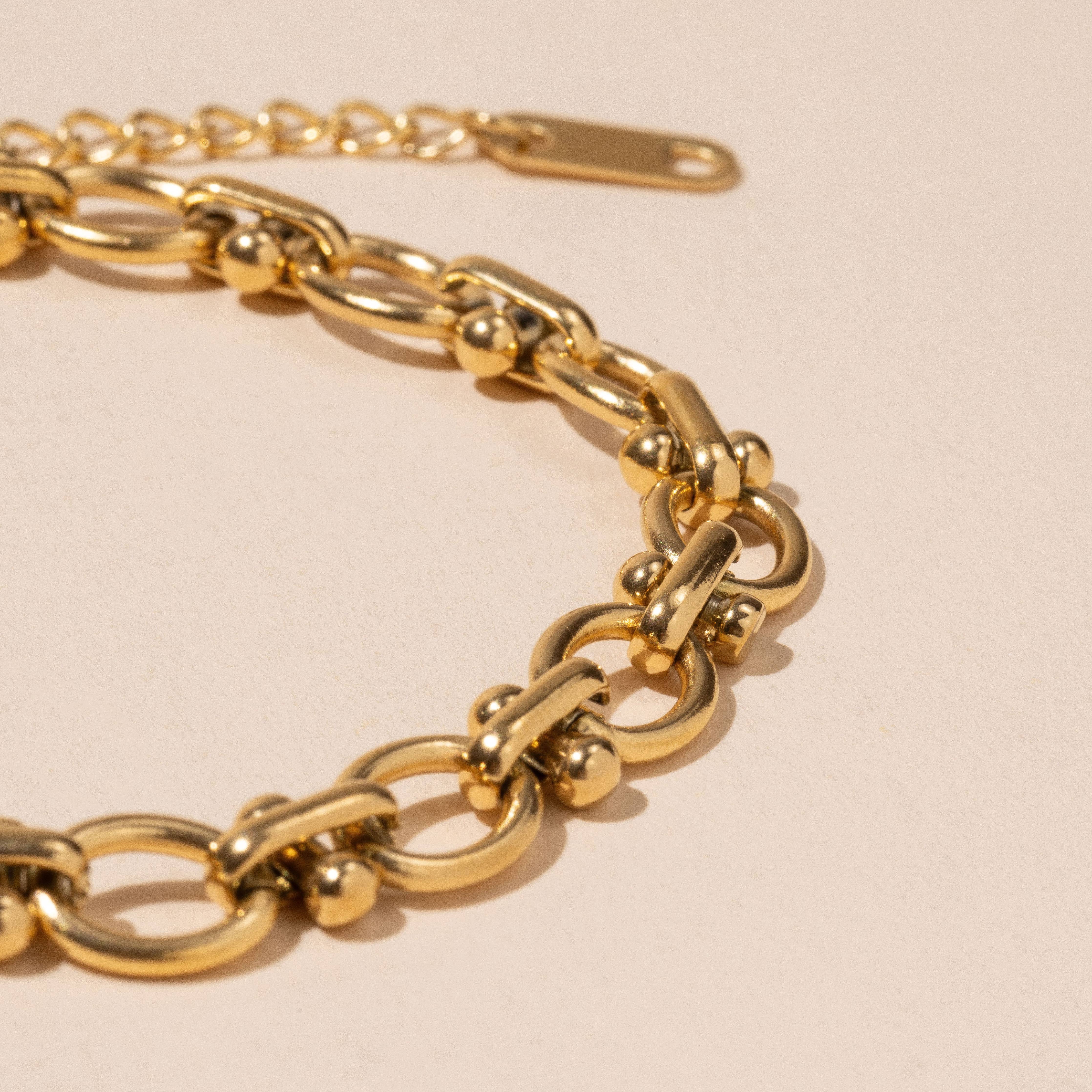 Gold chain bracelet on a beige background