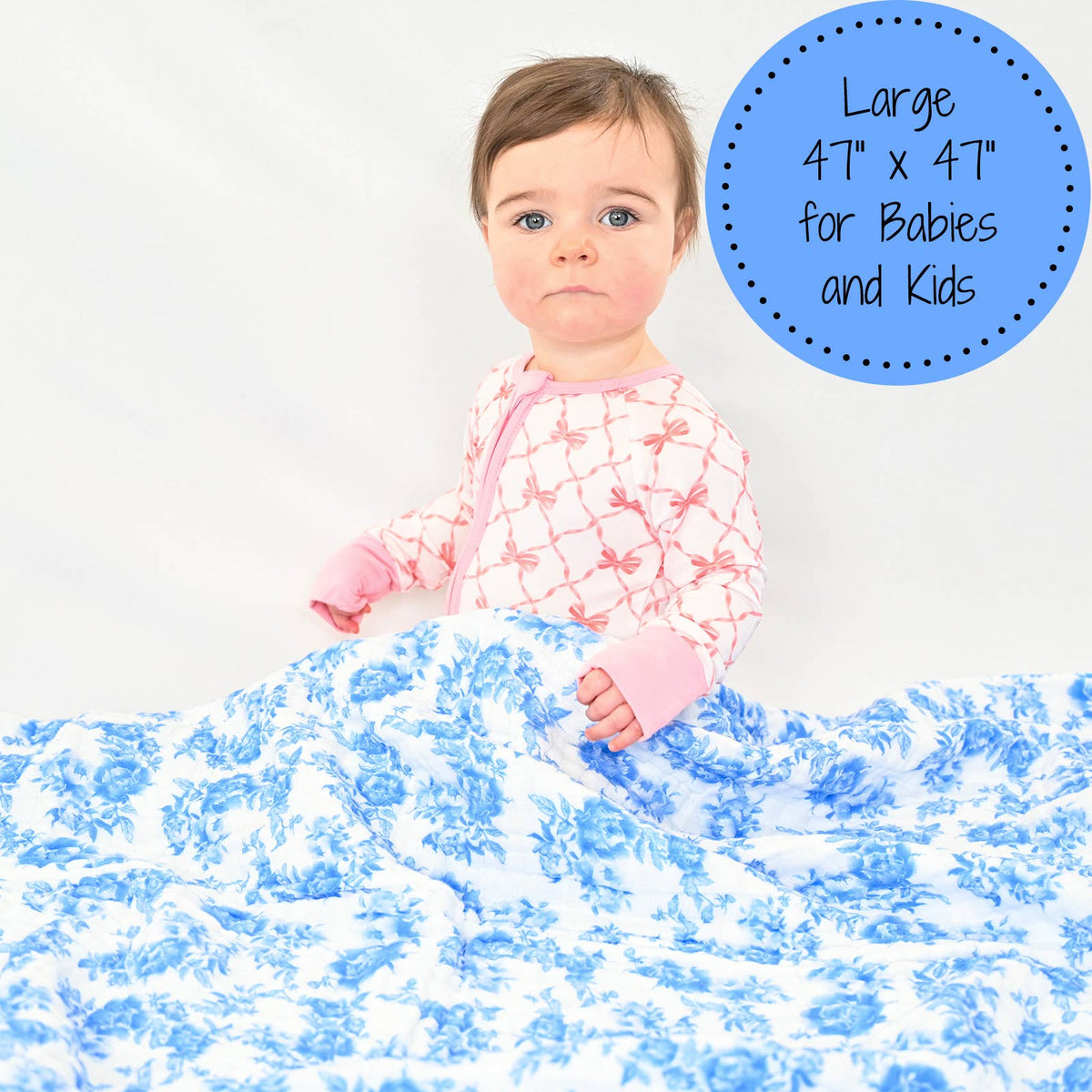 Child playing on a large blue and white blanket with text about size and use.