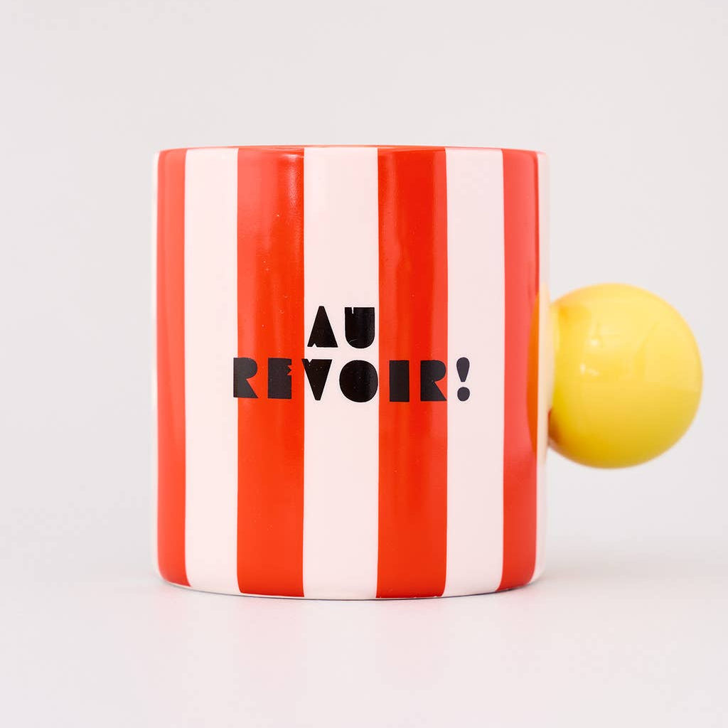 Striped mug with 'AU REVOIR!' text and a yellow object on a white background