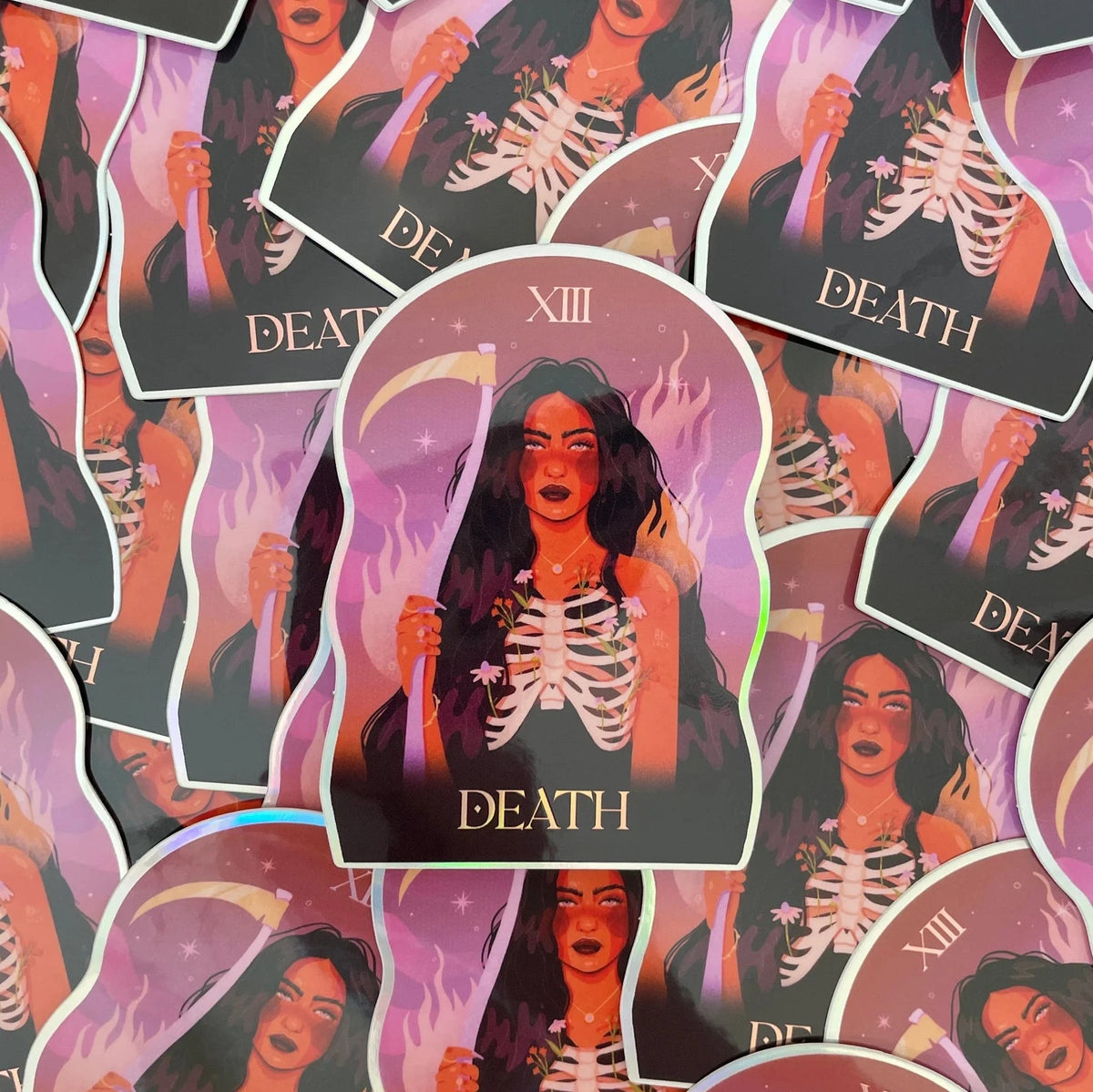 Death tarot Holographic sticker based off of artwork by Brittany Keller. This sticker has a glossy vinyl finish with holographic elements on the cutline. Death has long, wavy brown hair and her ribs can be seen outside her body and botanicals are growing from within. She is holding a scythe.