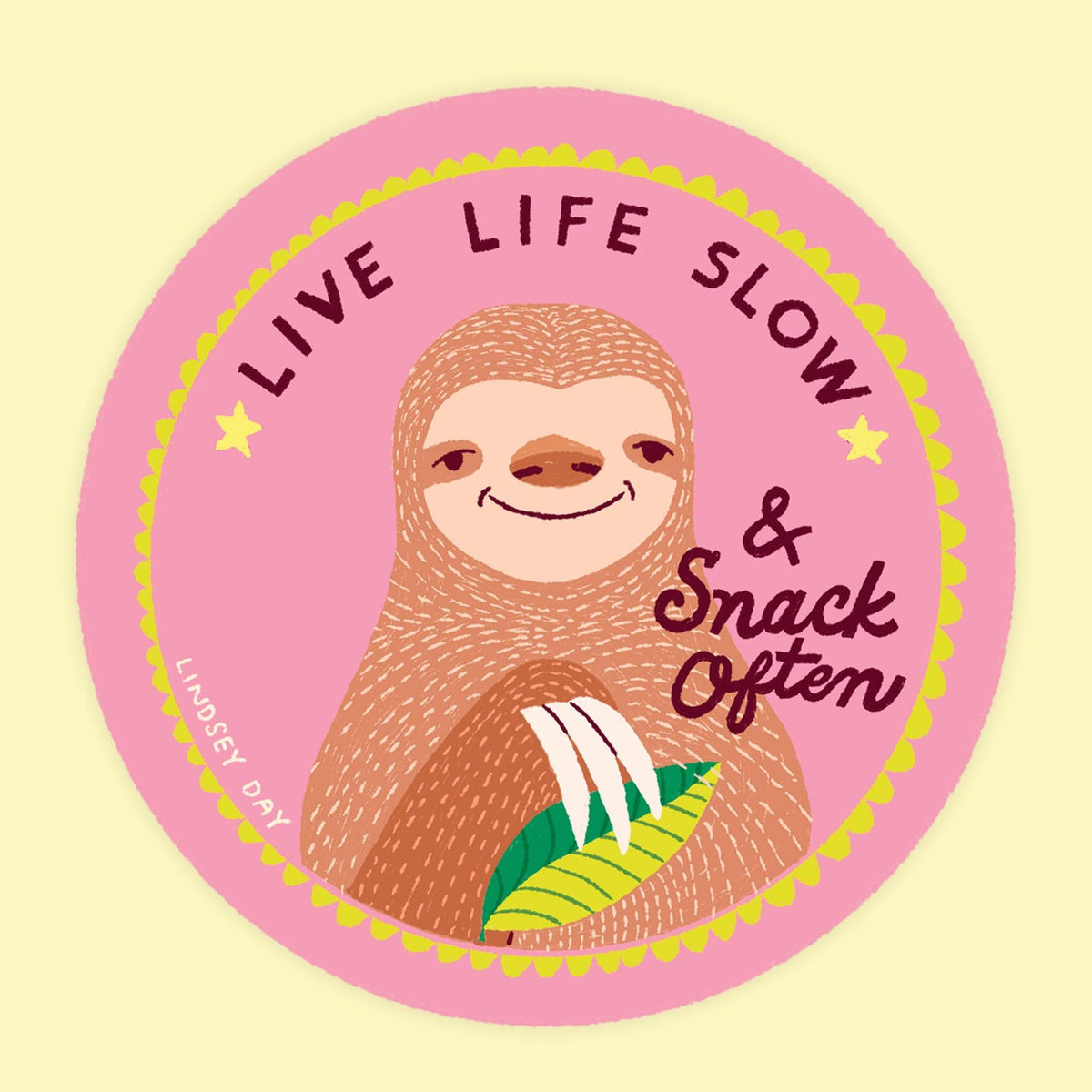 Circle pink sticker with a sloth, and words "live life slow & snack often".