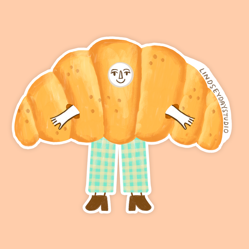 Croissant sticker with a face arms and legs.