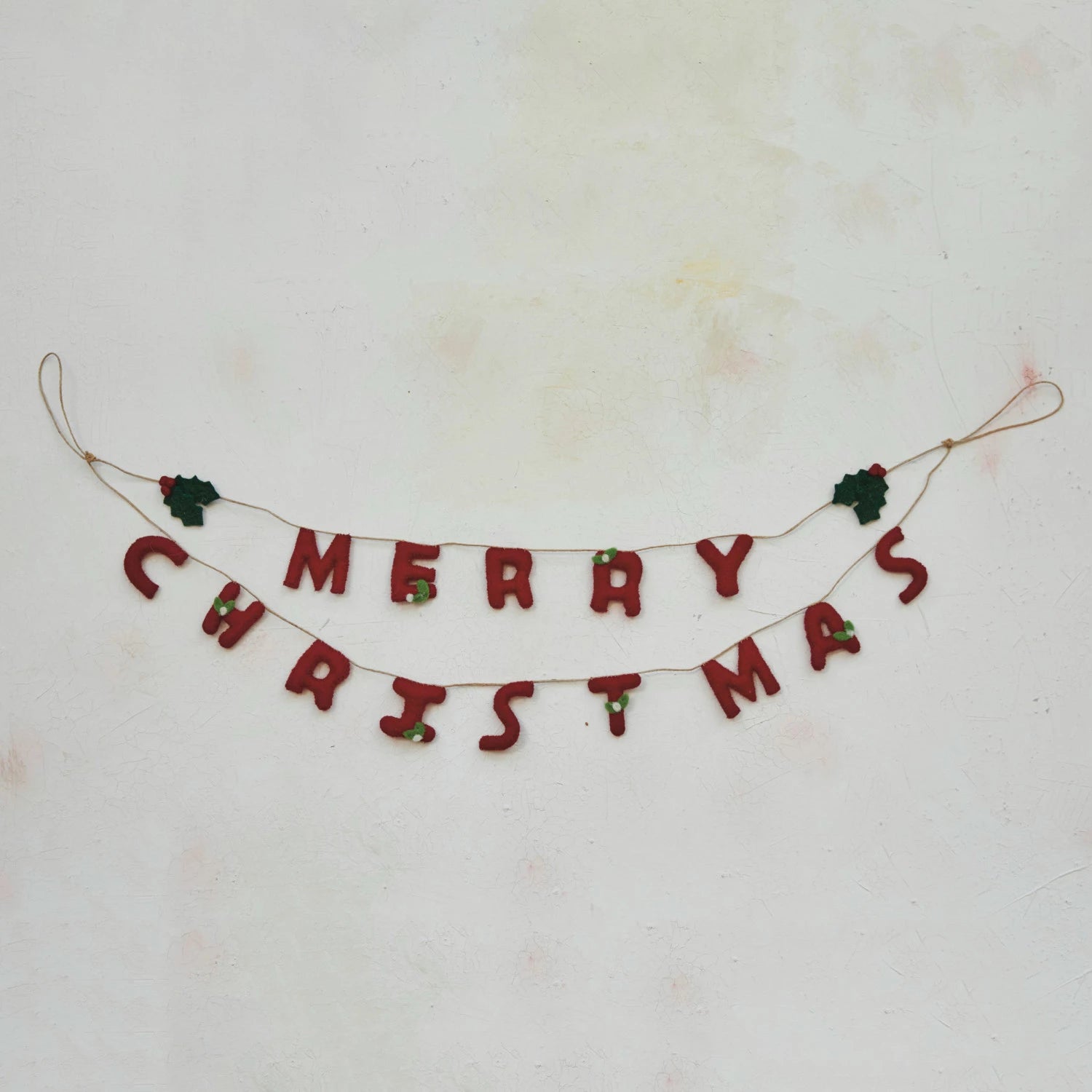 This handcrafted garland is a celebration of the holiday spirit, featuring lush wool felt holly leaves and bright red berries that spell out "Merry Christmas". Each element is meticulously created to bring a piece of the holiday cheer into the home.