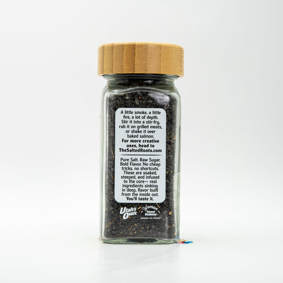 Back view of glass salt jar with wooden lid and labels. 