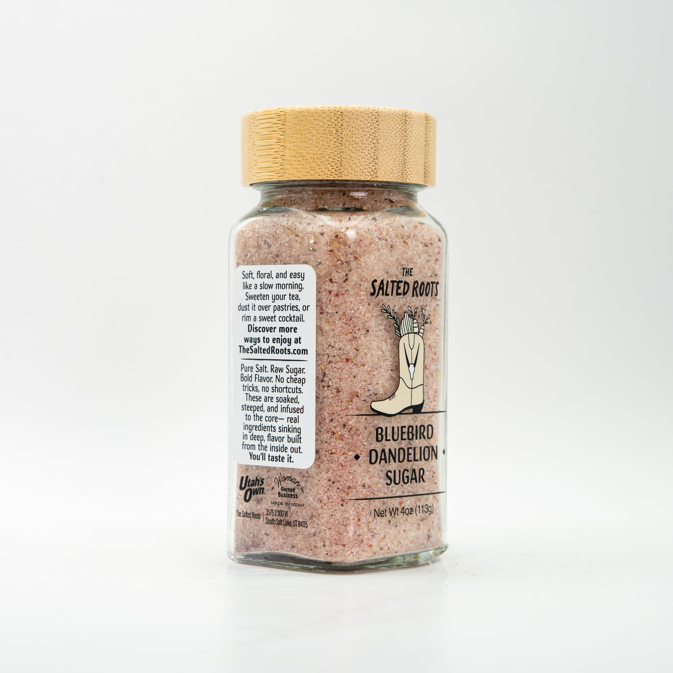 Side view of glass salt jar with wooden lid and labels. 
