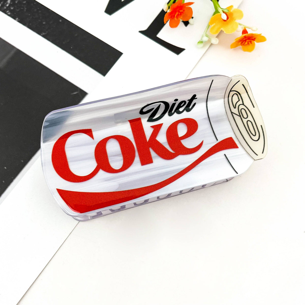 Add a playful pop to your accessory collection with this diet-coke hair claw. Its quirky design instantly catches attention, making it a fun conversation starter and a perfect match for customers who love novelty fashion.

Made from durable acetate-style material with a glossy finish, this claw clip holds hair firmly in place while keeping a lightweight and comfortable feel.