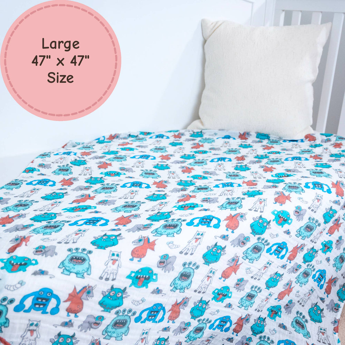 Children's monster-themed bed sheet on a bed with a white pillow.