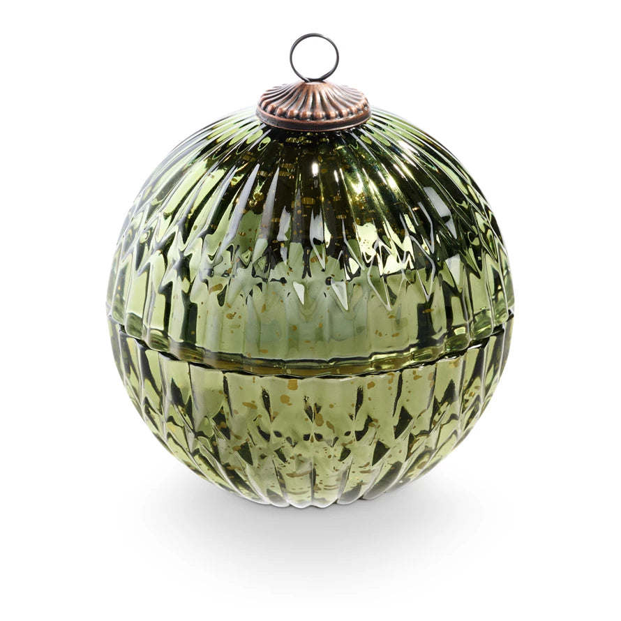 Green glass ornament candle with textured surface and metallic top on a white background