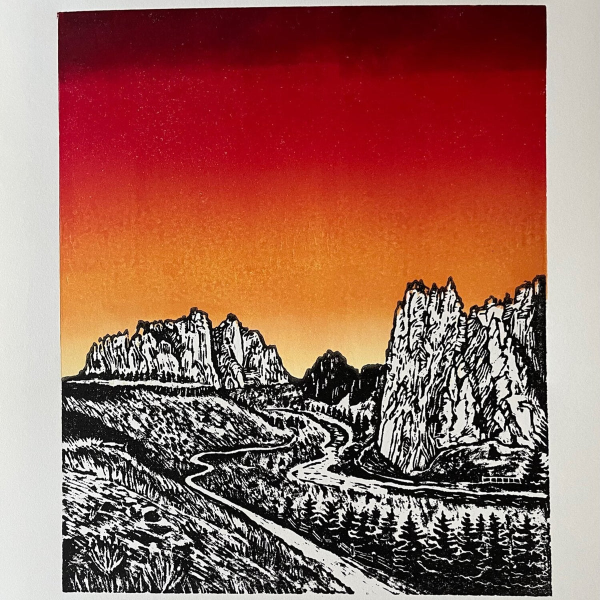 hand carved and pressed black and white 15x20 print of Smith Rock with a red and orange sunset