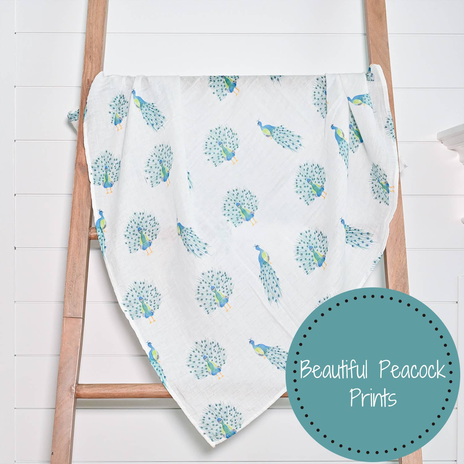 Blanket with peacock pattern on a wooden ladder against a white background