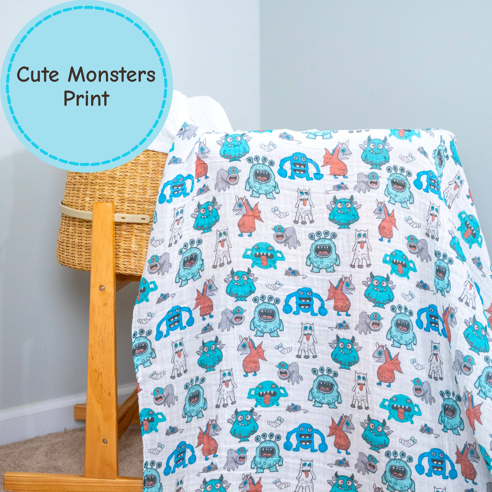 bed with a blanket featuring cute monster print next to a wooden basket.