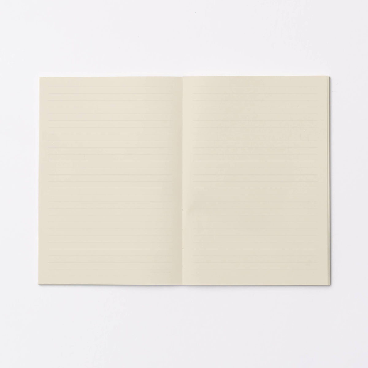 An open notebook with cream-colored, lined pages, displayed flat against a clean white background.