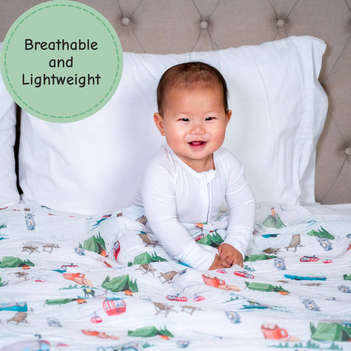 Baby sitting on a bed with colorful bedding, surrounded by pillows.